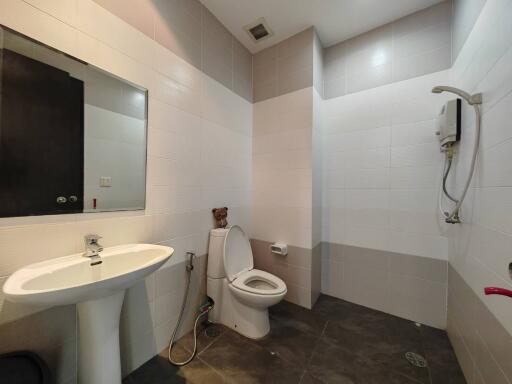 Modern white tiled bathroom with sink, toilet and shower