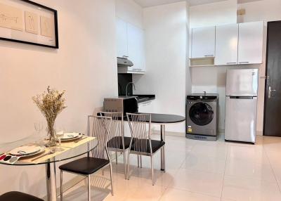 Modern kitchen with dining area, appliances and white cabinets