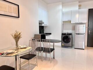 Modern kitchen with dining area, appliances and white cabinets