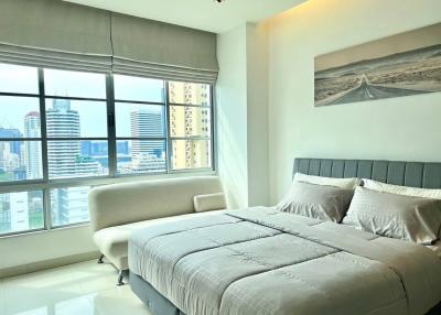 Modern bedroom with large window overlooking the city