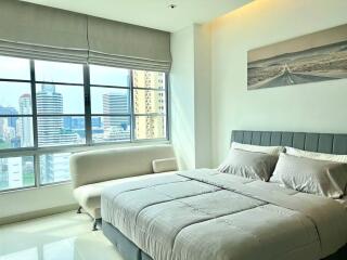 Modern bedroom with large window overlooking the city