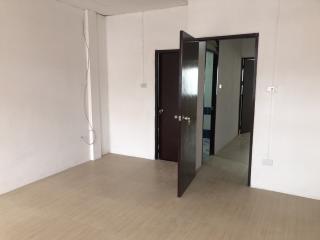 Empty interior space of a building with an open door leading to another room
