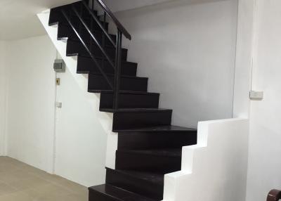 Modern staircase with dark wood steps and white walls in a residential home