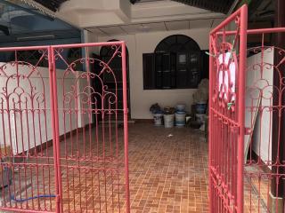 Enclosed front patio with red gate and tiled floor