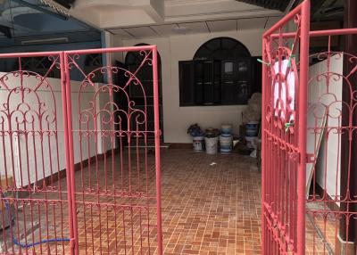 Enclosed front patio with red gate and tiled floor