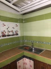 Compact kitchen with green and white tile backsplash