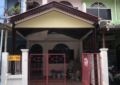 Exterior view of a two-story residential building with a red gate