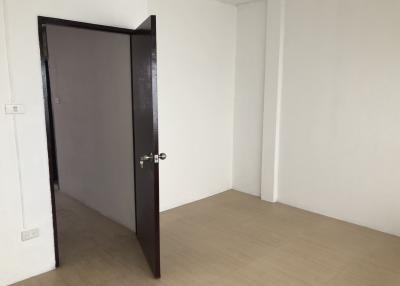 Empty bedroom with an open door and wooden flooring