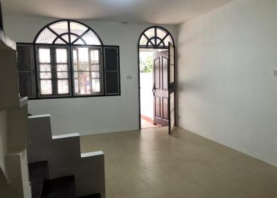 Spacious unfurnished room with staircase and multiple doors leading to other rooms