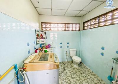 Compact bathroom with washing machine and blue tile walls