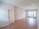 Spacious and bright empty living room with hardwood floors and large windows