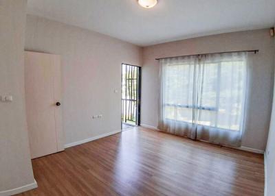 Empty living room with hardwood floors and natural light