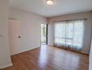 Empty living room with hardwood floors and natural light