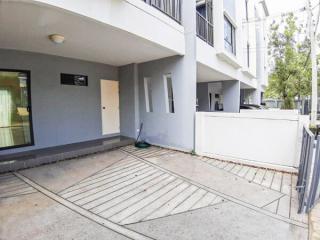 Front entrance of a modern residential building with parking space