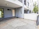 Front entrance of a modern residential building with parking space