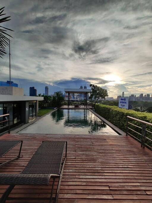 Modern rooftop swimming pool with city skyline at sunset