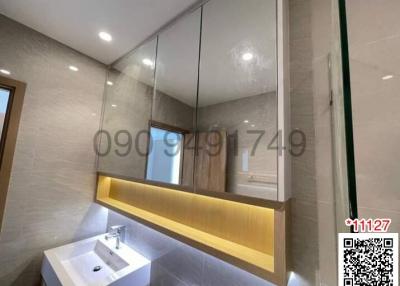 Modern bathroom with large mirror and well-lit vanity area