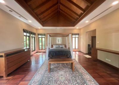 Spacious bedroom with high ceiling and wooden floors