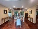 Elegant dining room with a large table set for a meal, terracotta tiled flooring, and natural light coming through glass doors