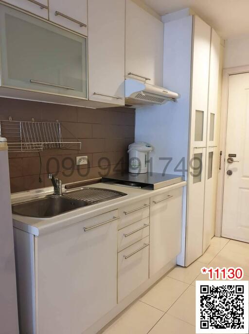 Compact kitchen with white cabinetry and modern appliances