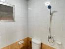 Small bathroom with basic amenities and tiled walls