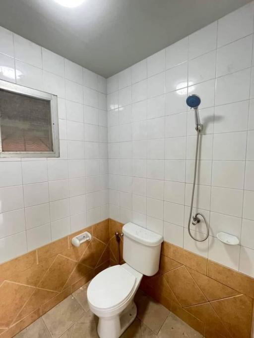Small bathroom with basic amenities and tiled walls
