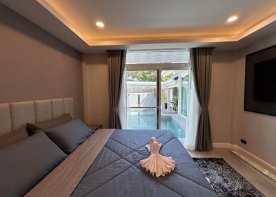 Modern bedroom with king-sized bed, ambient lighting, and access to outdoor patio