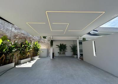 Modern building exterior with stylish ceiling design and green plants