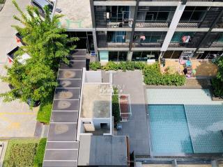 Aerial view of a modern residential building with pool and parking
