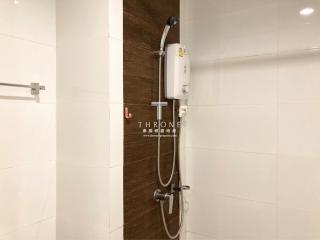 Compact bathroom with modern electric shower and sleek white tiles