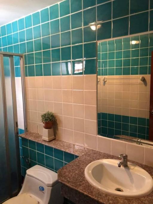 Modern bathroom with blue tiles and sliding shower doors