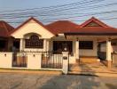 Front view of a residential house with red tiled roof and gated entrance