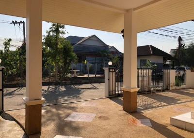 Paved front patio of a residential house with a view of the gate and street
