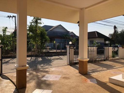 Paved front patio of a residential house with a view of the gate and street