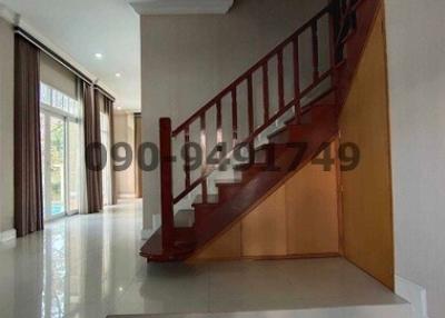 Spacious interior with shiny tiled flooring and a wooden staircase
