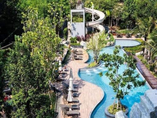 Luxurious resort-style pool area with waterslide and lush landscaping