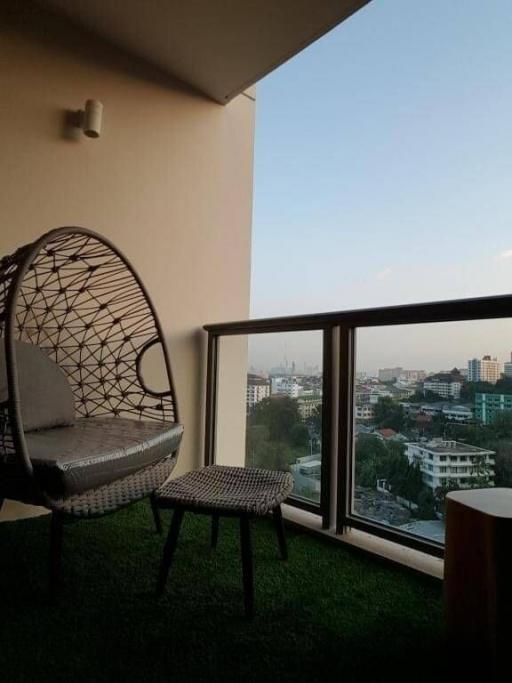 Cozy balcony with modern wicker chair overlooking the city