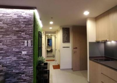 Modern apartment hallway with kitchenette and decorative stone wall