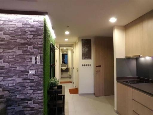 Modern apartment hallway with kitchenette and decorative stone wall