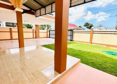 Spacious patio area with glossy tiled flooring and an adjoining grass lawn