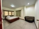 Spacious bedroom with a double bed and a comfortable sofa