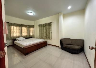 Spacious bedroom with a double bed and a comfortable sofa