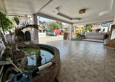Spacious patio with tiled flooring and a small pond