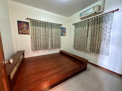 Spacious bedroom with wooden bed frame and air conditioning