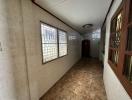 Long narrow hallway with tiled floors and security barred windows