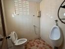 Bathroom with white tiles, toilet, and urinal