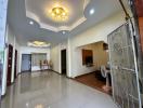 Spacious living room with tiled flooring, modern lighting, and elegant entrance gate