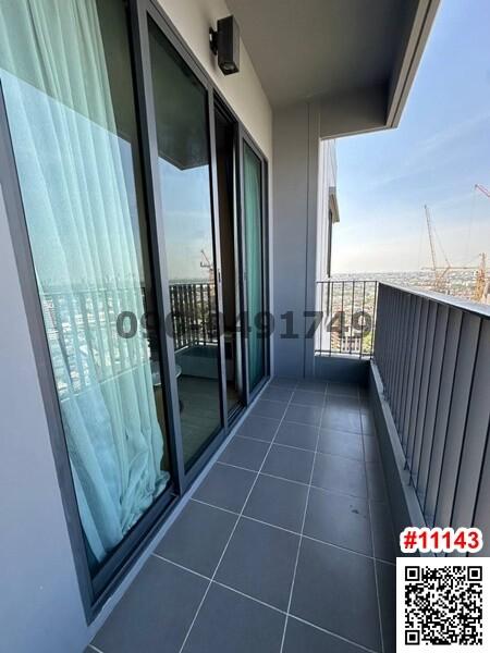 A balcony with a view, showing sliding glass doors and railing