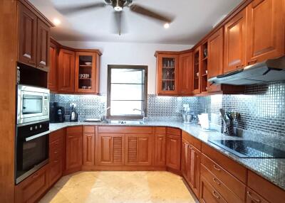 Spacious kitchen with cherry wood cabinets and stainless steel appliances