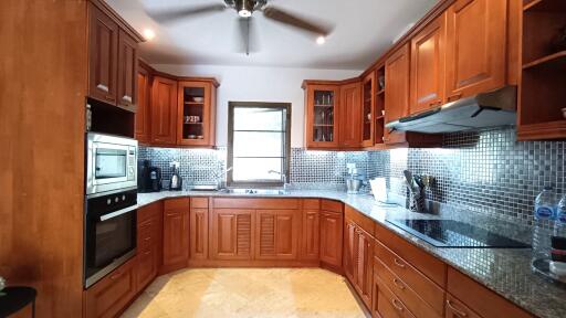 Spacious kitchen with cherry wood cabinets and stainless steel appliances